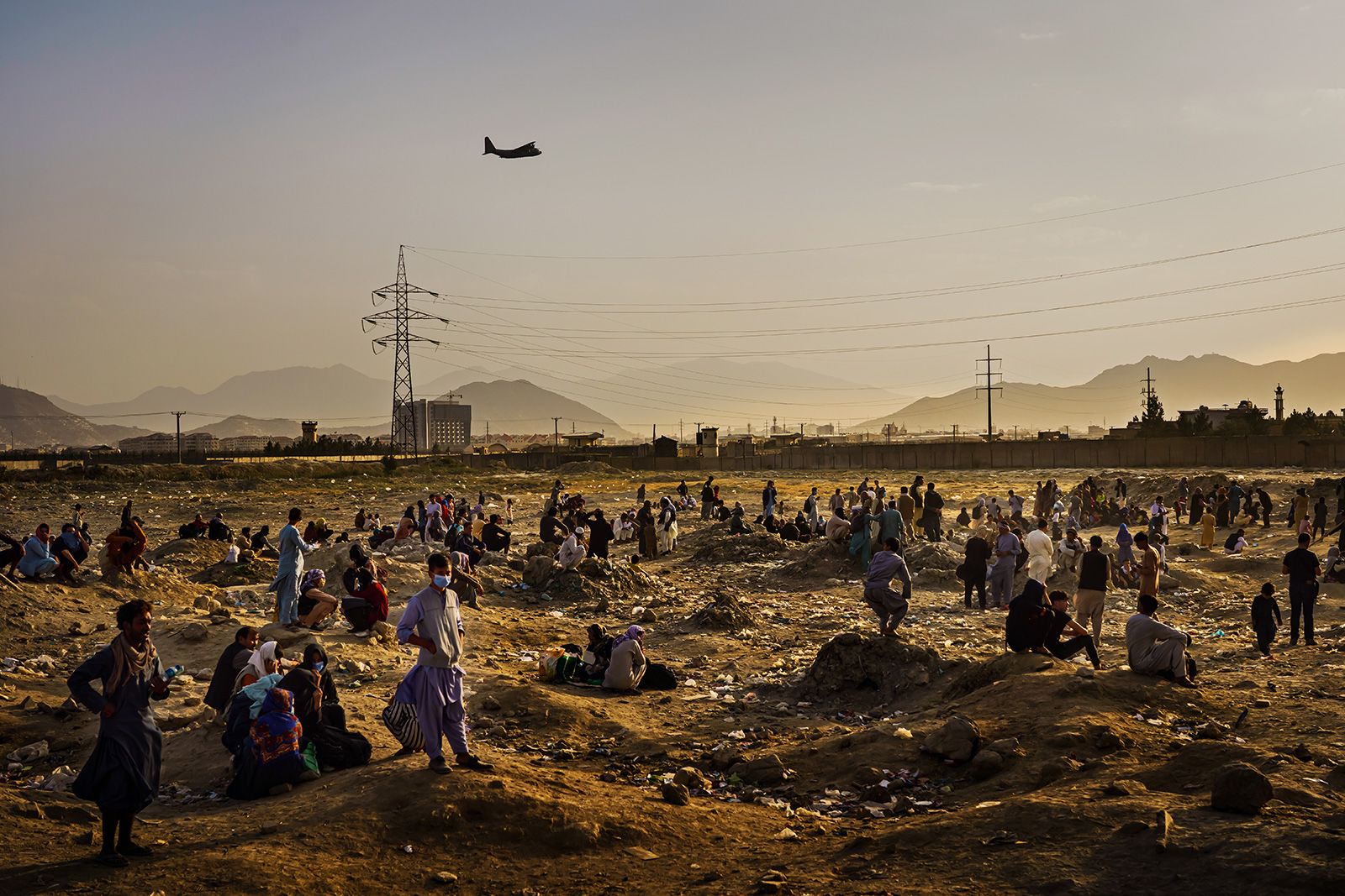 August 23, 2021: Airlifts were a frequent occurrence as Kabul fell to the Taliban. Here, Afghans look up forlornly at a military transport plane departing overhead.