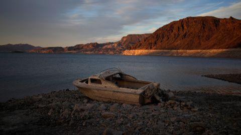 A formerly submerged boat sits high and dry along the shoreline of Lake Mead.