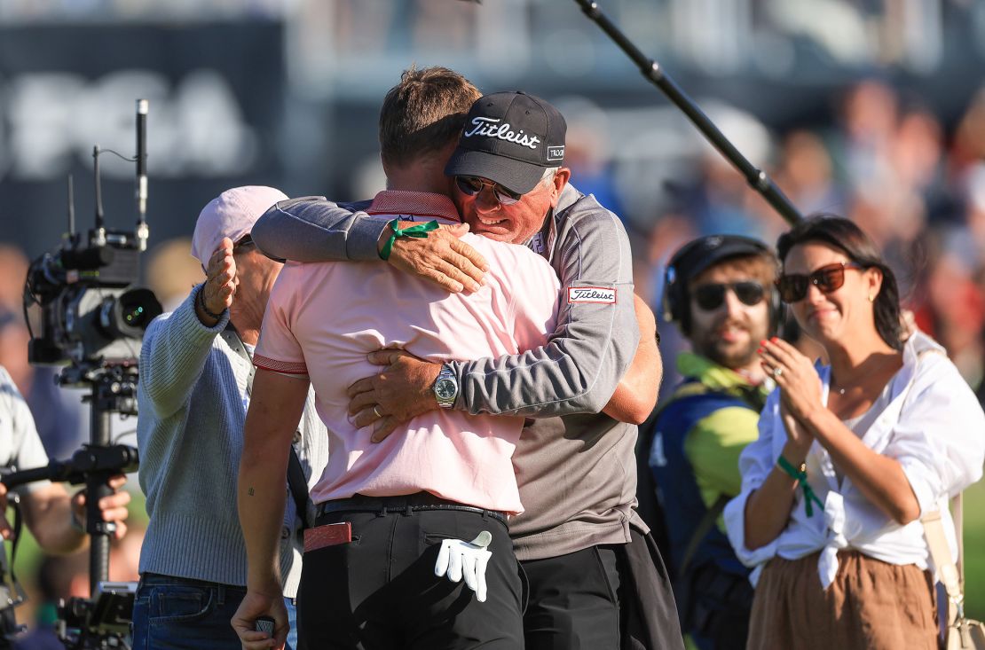 Thomas is congratulated after his victory by his father Mike Thomas, on the 18th green.