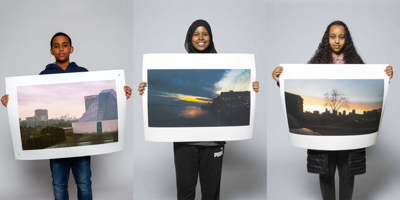 Students Yassir Ahmed, Safa Hassan and Samira Abdi pose with photographs they made as part of the mentorship program.