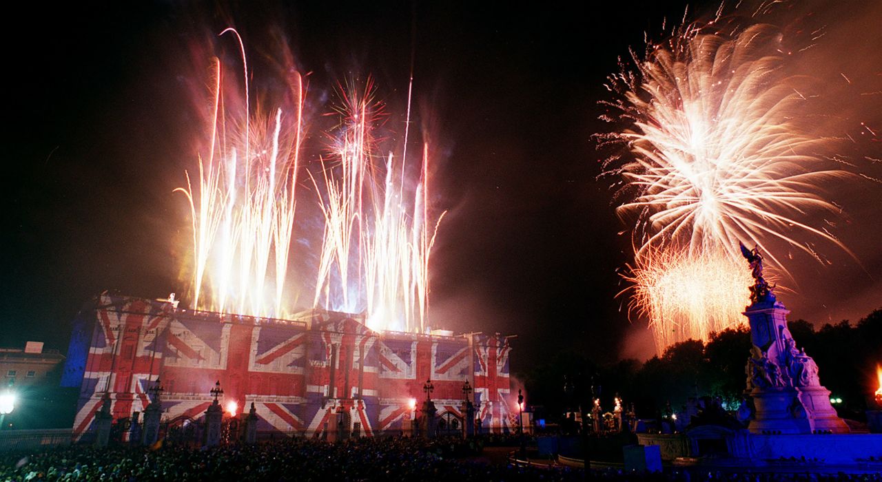 Buckingham Palace is emblazoned with images of the Union Jack flag while fireworks light up the sky after the concert.