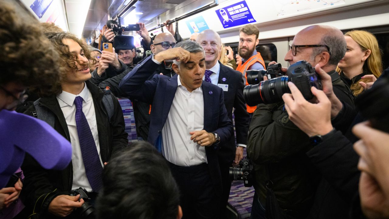 London Mayor Sadiq Khan pretends to mop his brow with relief as the first Elizabeth line trains leave on time.