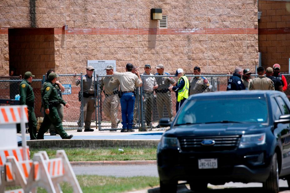 Law enforcement officials and other first responders gather outside the school following the shooting. 