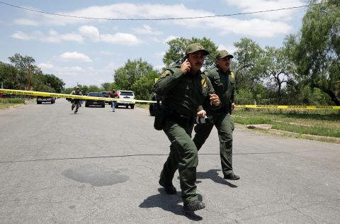 Law enforcement personnel run near the scene of the shooting on May 24. US Customs and Border Protection, which is the largest law enforcement agency in the area, assisted with the response.