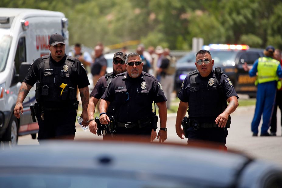 Police walk near the school following the shooting.