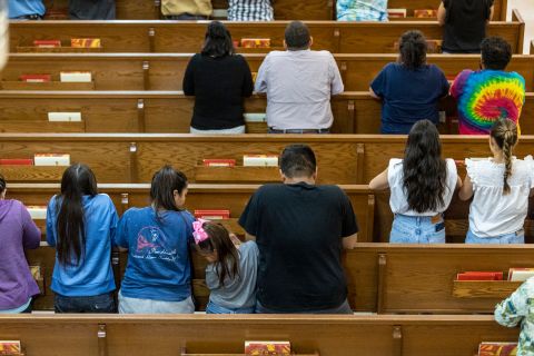 People pray Tuesday night at Sacred Heart Church in Uvalde.