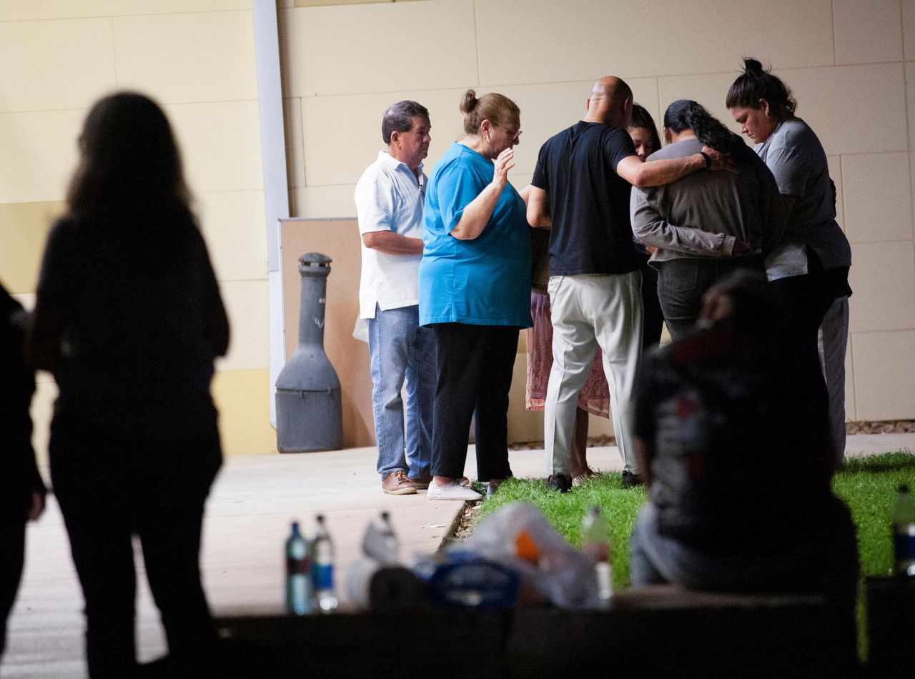 People pray outside the SSGT Willie de Leon Civic Center in Uvalde on May 24. The civic center is where students were transported after the shooting.