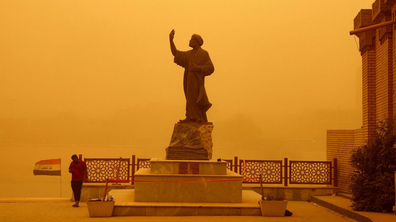 A man stands near a statue of the famous Arab poet al-Mutanabbi during a sandstorm in Baghdad, Iraq, on May 23.