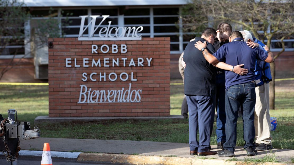 People gather Wednesday at Robb Elementary School.