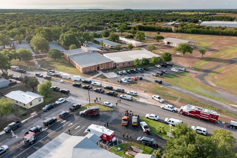 Law enforcement vehicles are lined up outside the school on May 25.