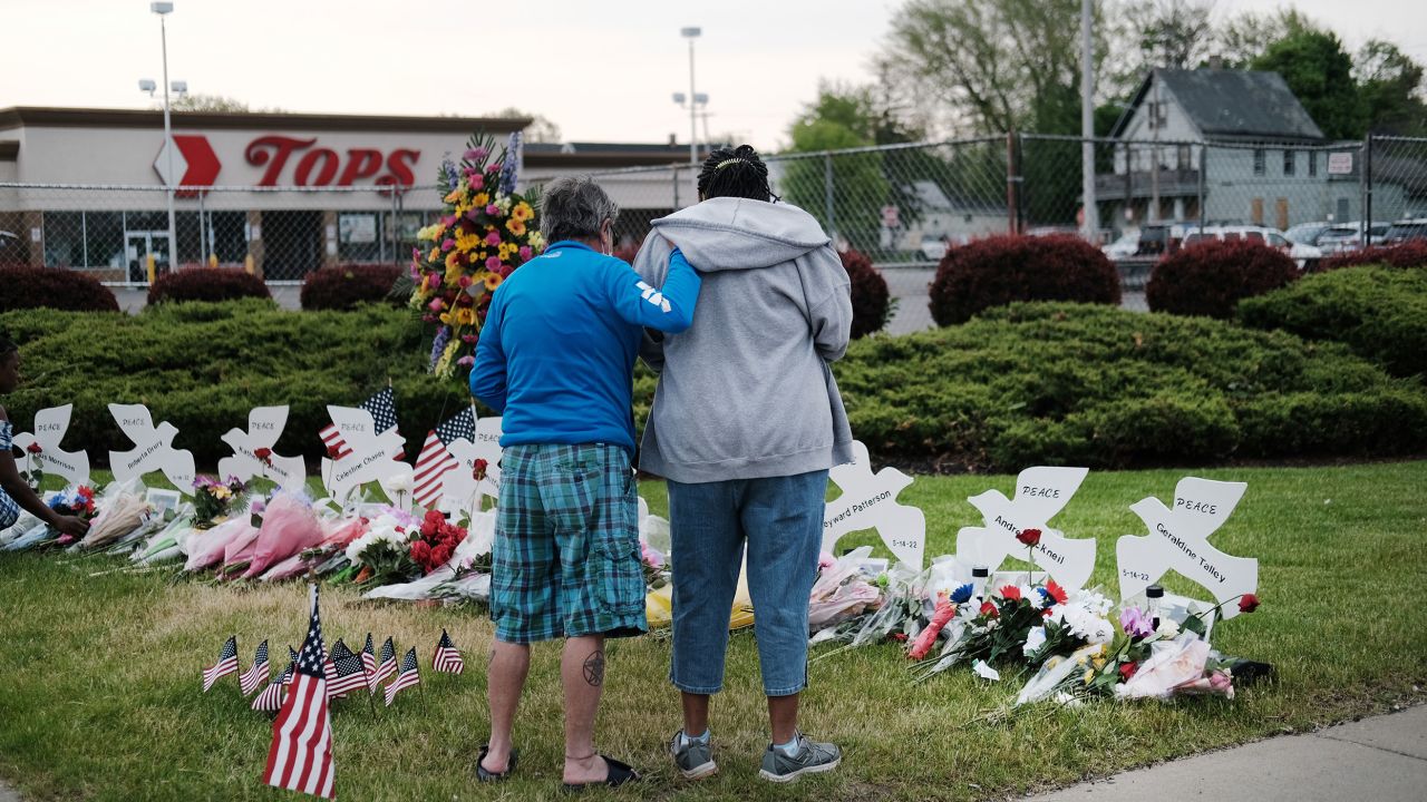 BUFFALO, NEW YORK - MAY 20: People gather at a memorial for the shooting victims outside of Tops market on May 20, 2022 in Buffalo, New York. 18-year-old Payton Gendron is accused of the mass shooting that killed 10 people at the Tops grocery store on the east side of Buffalo on May 14th and is being investigated as a hate crime.