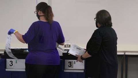 Maricopa County Elections Department officials in Phoenix feed test ballots into tabulating machines as they conduct a post-election logic and accuracy test on November 18, 2020.