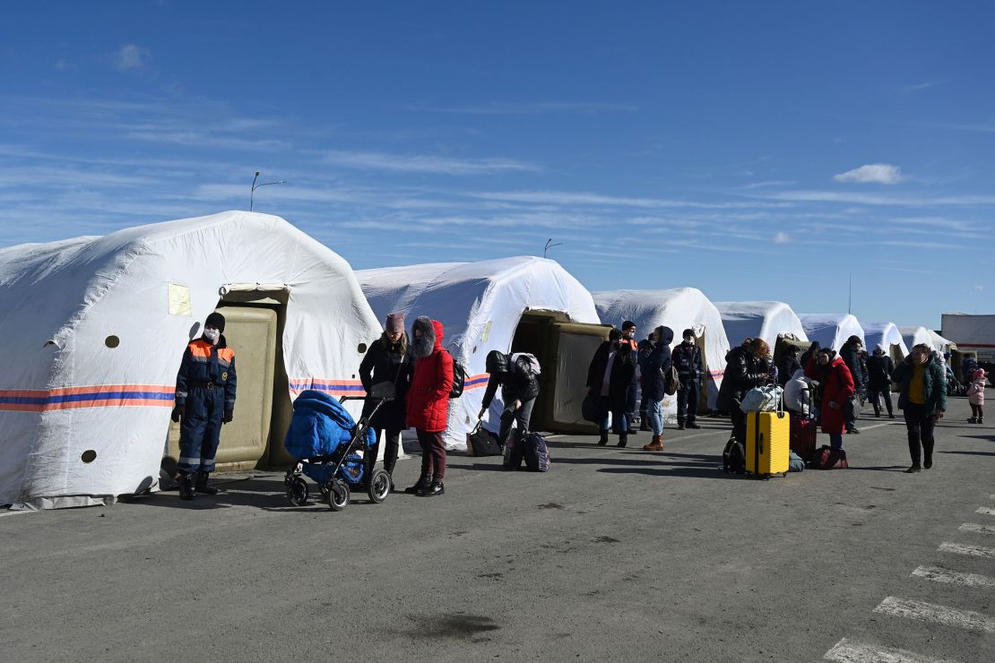 People gather at a tent camp at the Matveyev Kurgan border checkpoint after evacuating from Donetsk, the territory controlled by pro-Russian militants in eastern Ukraine, early Saturday, Feb. 19, 2022. 