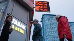People line up near Euro and U.S. dollars rates to ruble sign board at the entrance to the exchange office on May 25, 2022 in Moscow, Russia. Russia moved closer to a default on Wednesday after the U.S. Treasury let a key sanctions exemption expire. 