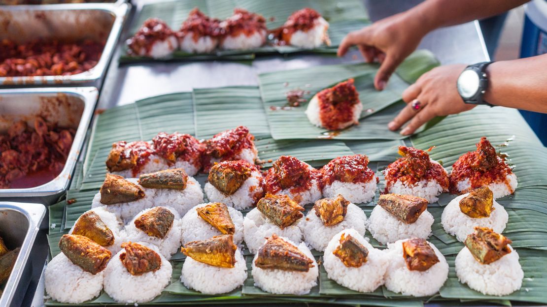 Nasi lemak features a variety of ingredients set on a bed of coconut rice.  