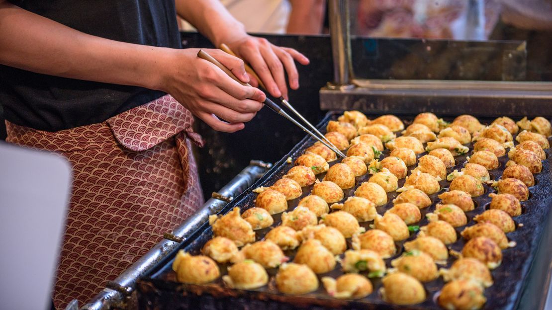 Takoyaki being prepared at a foodstall in Osaka, Japan.