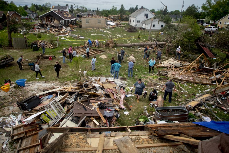 More than two dozen people work together to help clean up what's left of a home in Gaylord, Michigan, on Saturday, May 21. A <a href="https://www.cnn.com/2022/05/21/weather/gaylord-michigan-tornado-saturday/index.html" target="_blank">powerful tornado</a> ripped roofs off buildings and flipped cars in Gaylord the day before, prompting the governor to declare a state of emergency for the area.