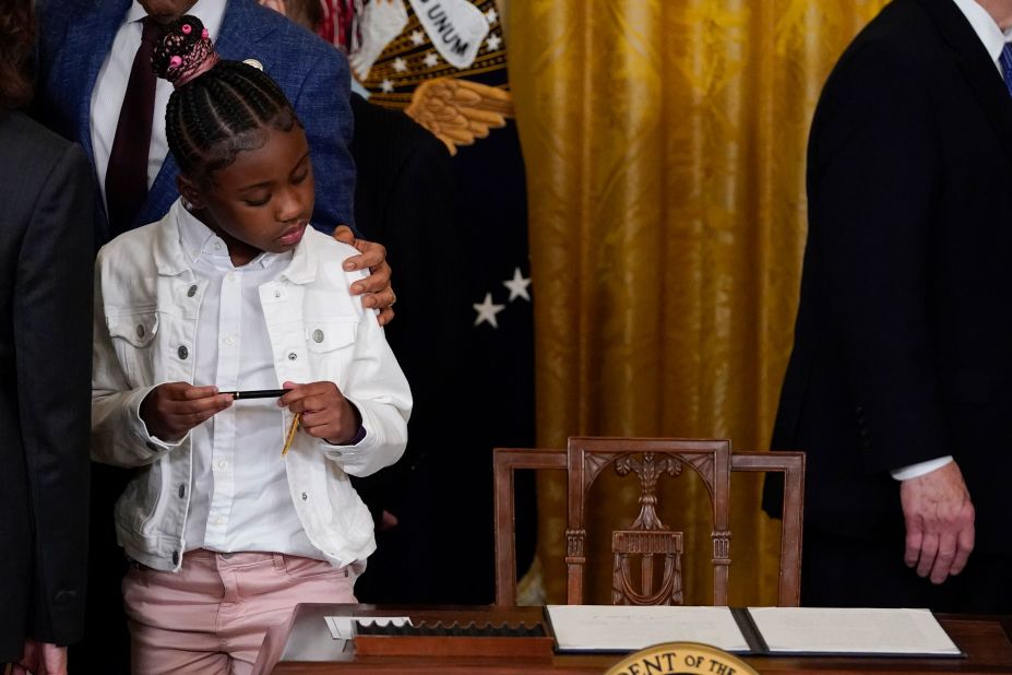Gianna Floyd, the daughter of George Floyd, looks at an executive order that <a href="https://www.cnn.com/2022/05/25/politics/joe-biden-texas-executive-order-police/index.html" target="_blank">US President Joe Biden signed</a> at the White House on Wednesday, May 25. The order, signed on the second anniversary of George Floyd's death, is aimed at federal policing reforms. Vice President Kamala Harris gifted Gianna with the pen that Biden used to sign the order. 