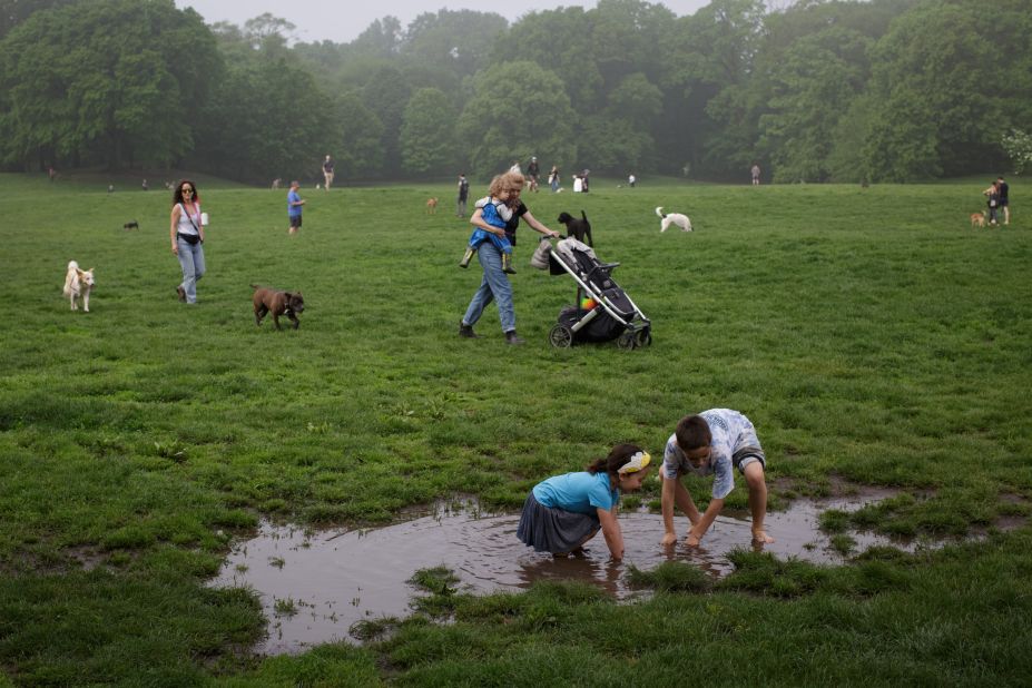 Siblings Naima and David play in a puddle in New York's Prospect Park on Sunday, May 21. The Northeast was experiencing <a href="https://www.cnn.com/2022/05/19/weather/heat-forecast-northeast-thursday/index.html" target="_blank">higher-than-normal temperatures</a> over the weekend.