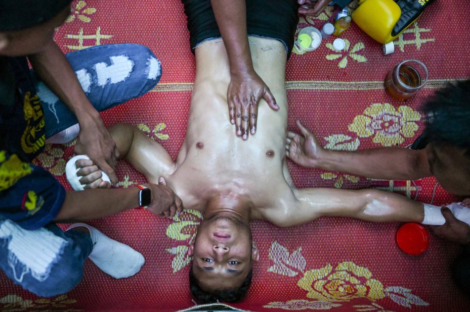 A Muay Thai boxer gets a massage from his coaches before a bout in Kota Bharu, Malaysia, on Saturday, May 20.