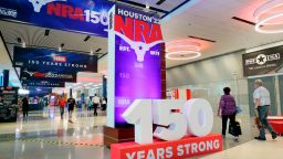 Convention attendants walk past some of the signage in the hallways outside of the exhibit halls at the NRA Annual Meeting held at the George R. Brown Convention Center Thursday, May 26, 2022, in Houston. (AP Photo/Michael Wyke)
