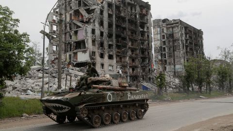 Service members of pro-Russian troops drive an armoured vehicle along a street past a destroyed residential building during Ukraine-Russia conflict in the town of Popasna in the Luhansk Region, Ukraine May 26, 2022. The writing on the vehicle reads: "Valkyrie". REUTERS/Alexander Ermochenko