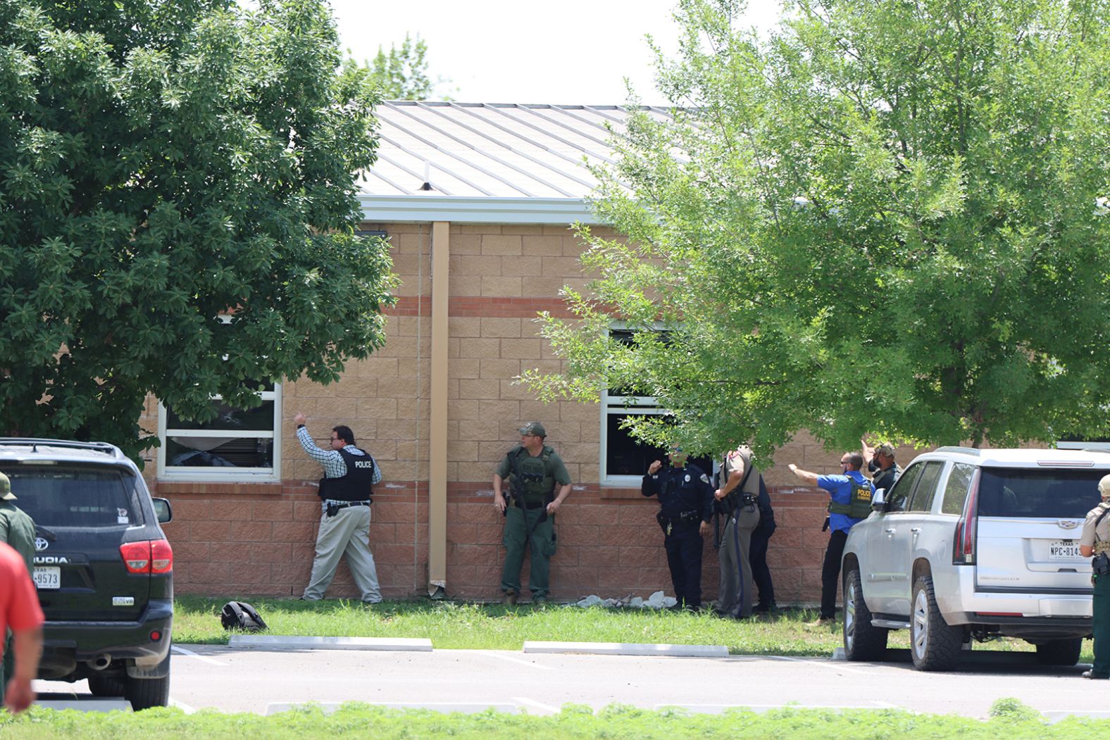 Law enforcement works near a school window before helping children out.