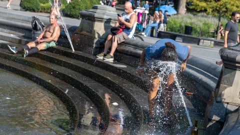 A person sprays her face to cool off in the fountain at Washington Square Park as temperatures reached close to 100 degrees Fahrenheit on August 12, 2021 in New York City. New York City is experiencing a heat wave with a heat index of 100+ causing extreme temperatures, humidity and possible storms. (Photo by Alexi Rosenfeld/Getty Images)