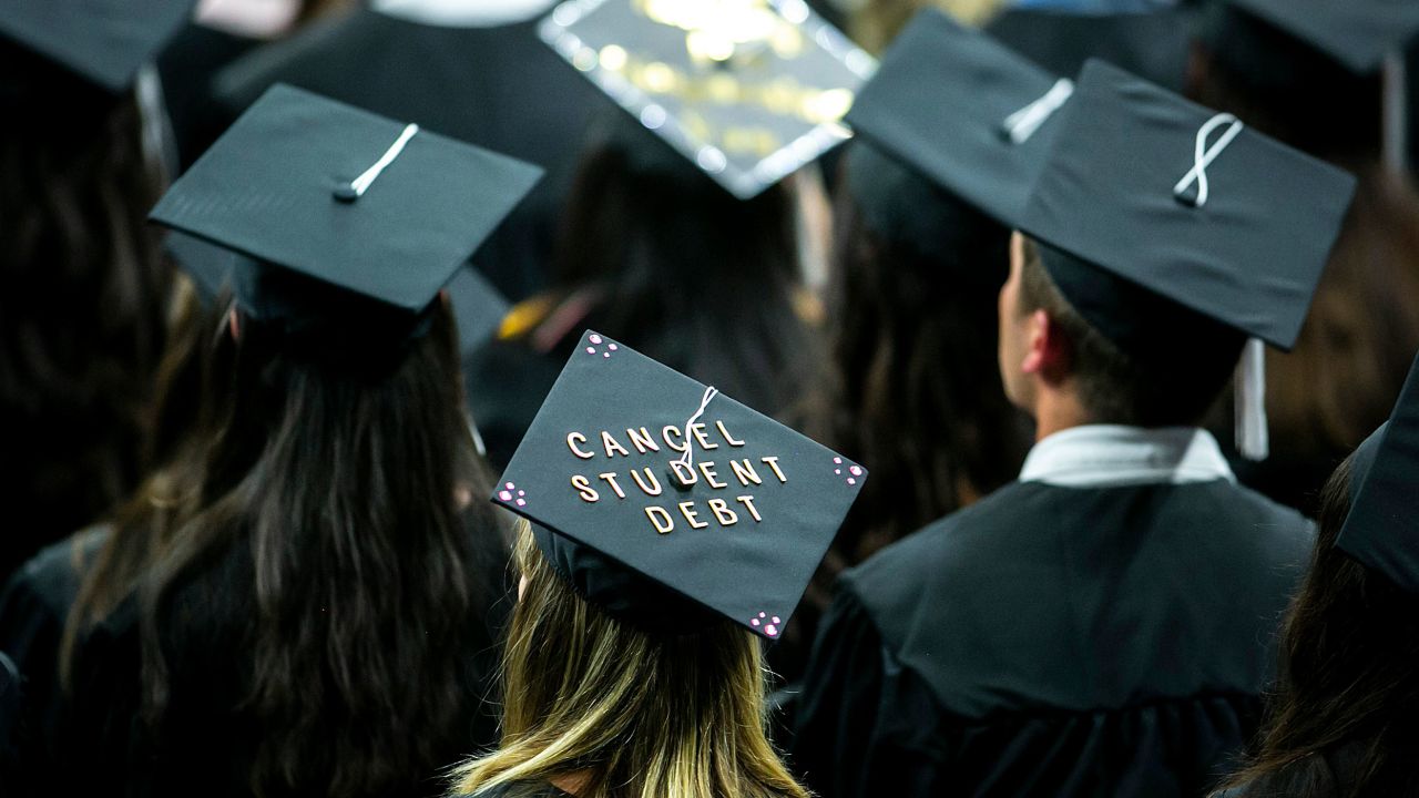 A University of Iowa graduate wears a cap with the words "Cancel student debt" during a commencement ceremony in Iowa City on May 14, 2022. 