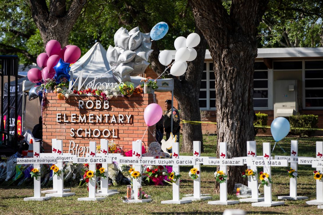 The names of the 19 children and two teachers who were killed are written on crosses in front of the school.