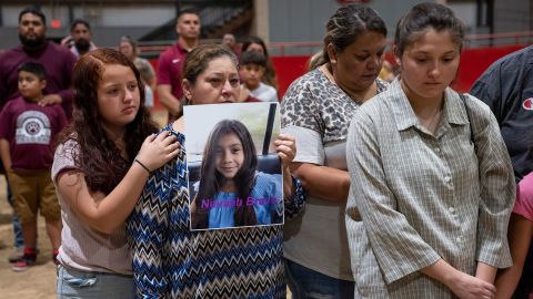 Esmeralda Bravo, center, holds a picture of her granddaughter Nevaeh Bravo, who was killed at  Robb Elementary School along with 18 other children and two teachers, during a vigil at Uvalde County Fairplex. 