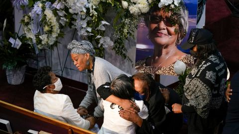 Mourners comfort Angela Crawley, seated at bottom left, and Robin Harris, daughters of Ruth Whitfield, who was killed during the supermarket shooting in Buffalo, New York.