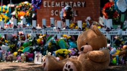 A large teddy bear is placed at a memorial in front of crosses bearing the names of the victims killed in this week's school shooting in Uvalde, Texas Saturday, May 28, 2022. (AP Photo/Jae C. Hong)