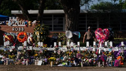 Flowers and candles are seen around crosses on May 28, 2022, at a memorial outside Robb Elementary School, in Uvalde, Texas, to honor the victims of the recent school shooting. 