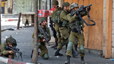 Soldados do exército israelense miram durante confrontos com manifestantes após a manifestação contra a manifestação anual 