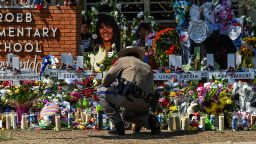 A police officer clears the makeshift memorial before the visit of US President Joe Biden at Robb Elementary School in Uvalde, Texas, on May 29, 2022. - The President and First Lady are in Uvalde to pay their respects following a school shooting. (Photo by CHANDAN KHANNA / AFP) (Photo by CHANDAN KHANNA/AFP via Getty Images)
