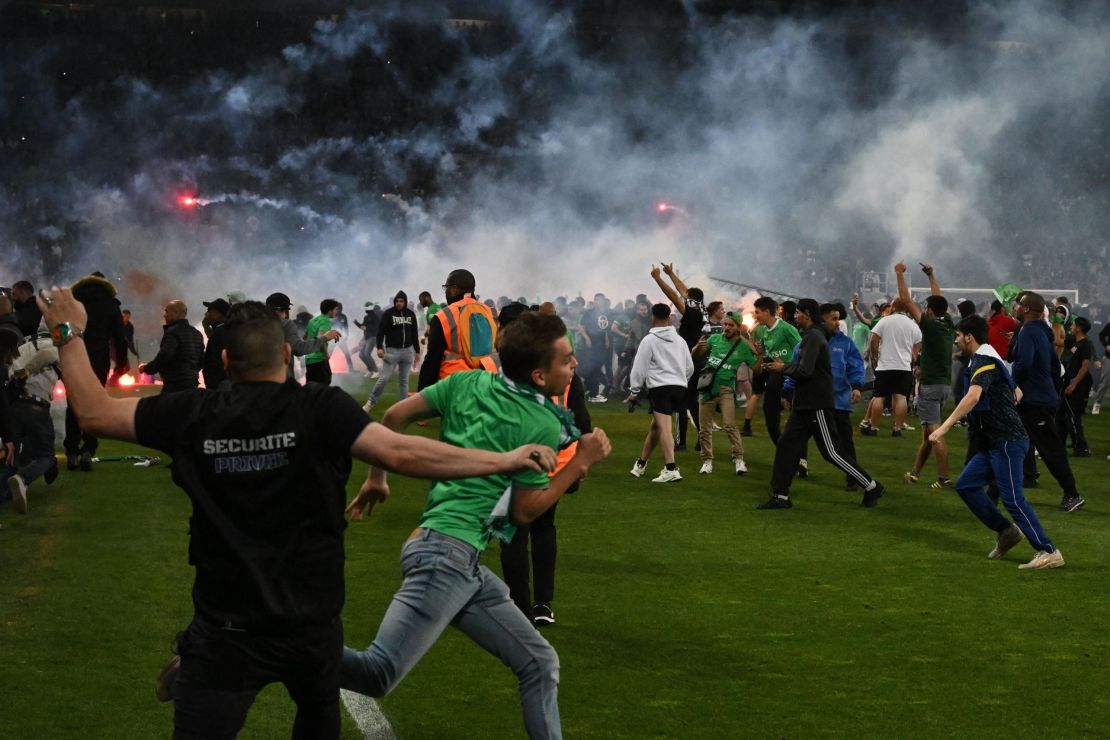 Saint-Étienne fans invade the pitch after being defeated at the end of the French relegation playoff second leg between AS St Étienne and AJ Auxerre at the Geoffroy Guichard Stadium.