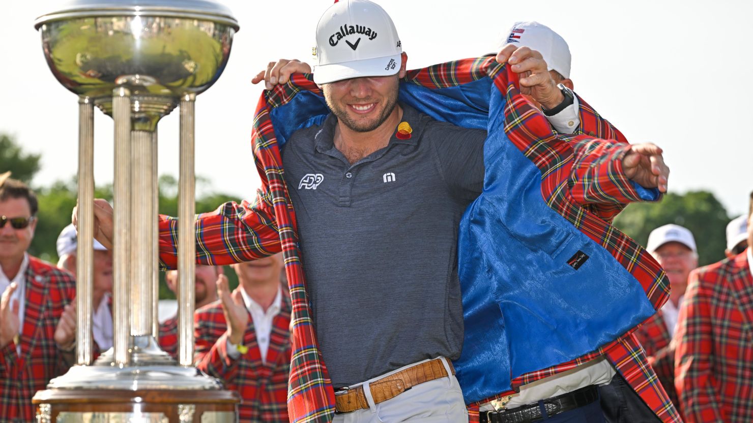 Sam Burns puts on the victor's tartan jacket during the trophy ceremony of the Charles Schwab Challenge.