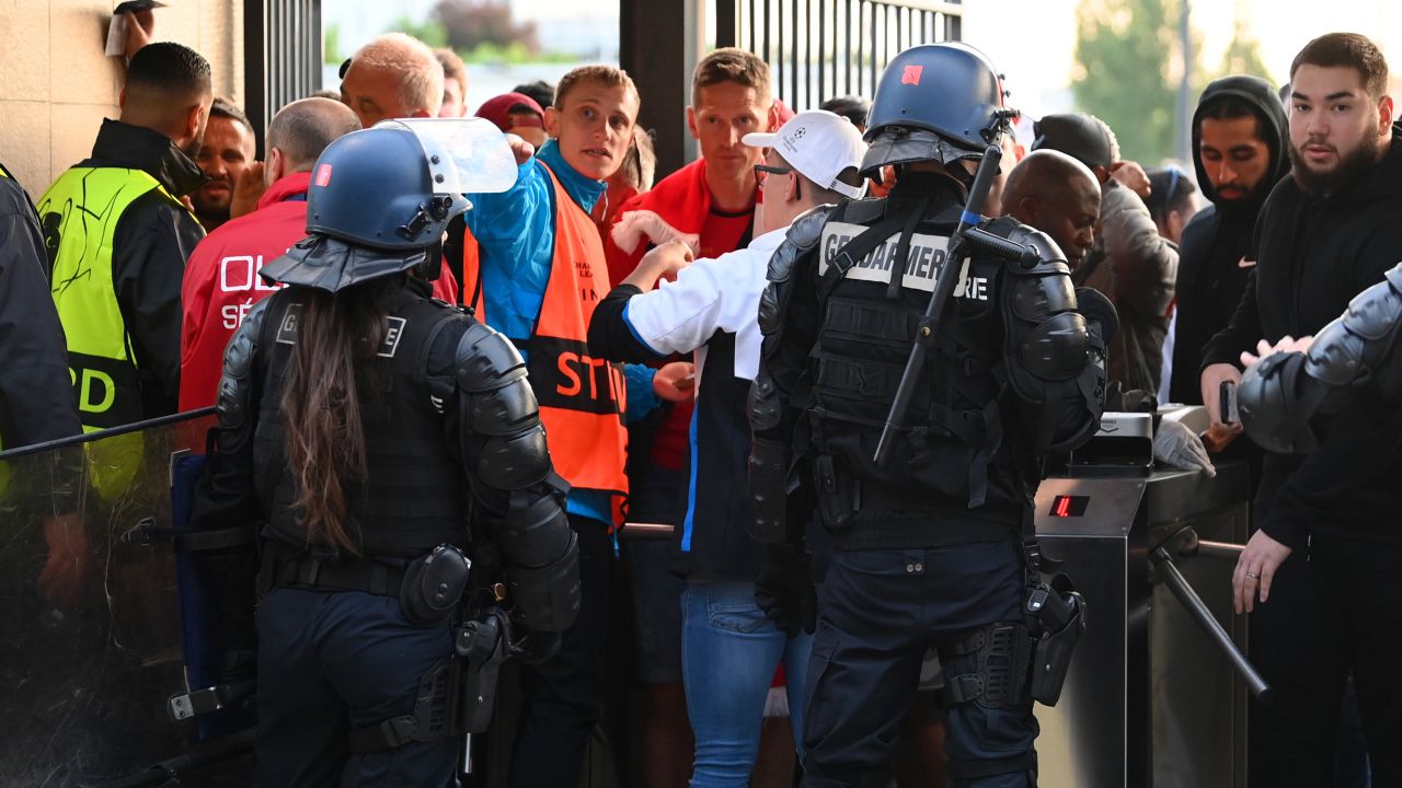 Police and stewards are seen as Liverpool fans queue outside the stadium prior to the UEFA Champions League final match between Liverpool and Real Madrid at Stade de France on May 28 in Paris. 