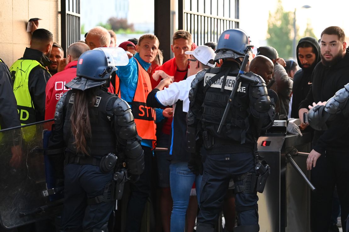 Police and stewards are seen as Liverpool fans queue outside the stadium prior to the UEFA Champions League final match between Liverpool and Real Madrid at Stade de France on May 28 in Paris. 