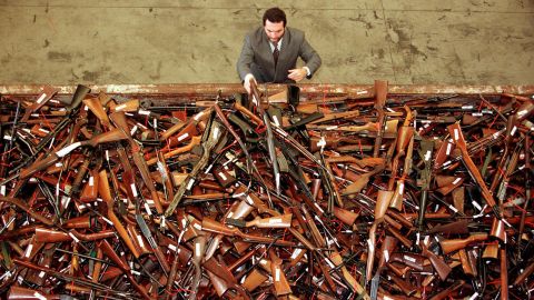 A gun reform project manager for the New South Wales Police looks at a pile of thousands of firearms in Sydney that had been handed in as part of the Australian government's buy-back scheme in July, 1996.  