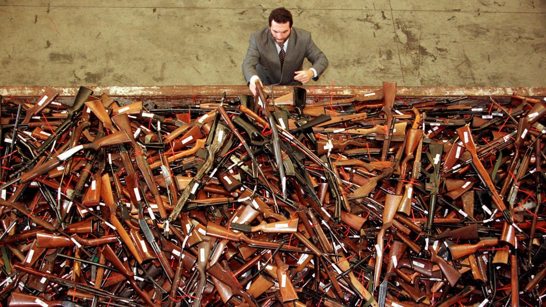 A gun reform project manager for the New South Wales Police looks at a pile of thousands of firearms in Sydney that had been handed in as part of the Australian government's buy-back scheme in July, 1996.