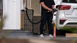 A driver holds a fuel nozzle at a Shell gas station in Hercules, California, U.S., on Tuesday, March 29, 2022. 