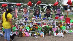 A woman looks down at a memorial for the 19 children and two adults killed on May 24th during a mass shooting at Robb Elementary School on May 30, 2022 in Uvalde, Texas.