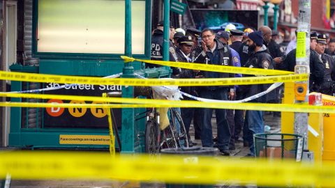 New York City Police Department personnel gather at the entrance to a subway stop in the Brooklyn borough of New York on April 12.