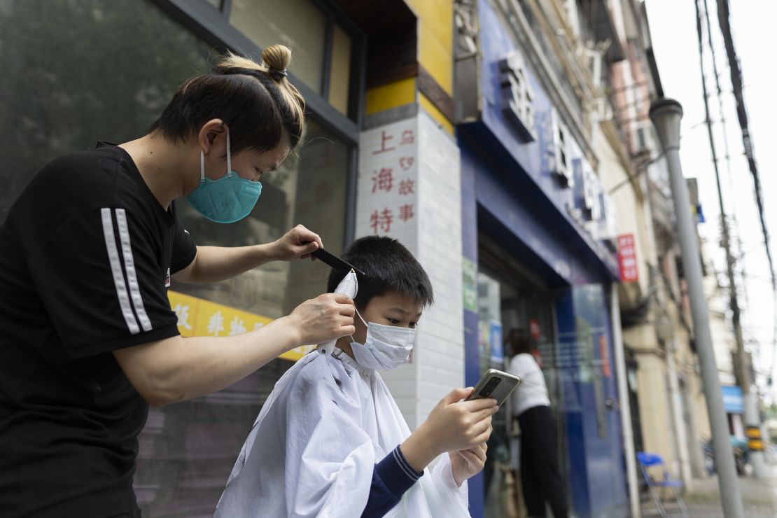 A barber cuts the hair of a boy in a Shanghai street on Wednesday.