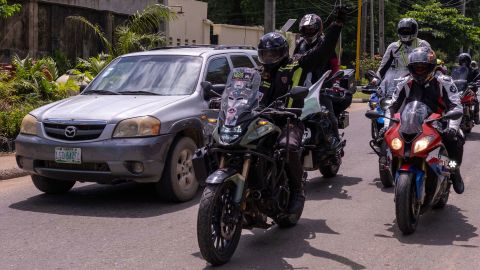 Kunle Adeyanju (C) arrives at the Ikeja Rotary club in Lagos on May 29, 2022, after a 41 day trip from London, by motorbike, to raise funds and awareness for the End Polio campaign.