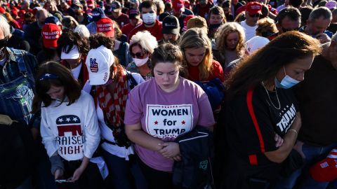 Kyndel Crouch, center, bows her head in prayer as she waits to hear President Donald Trump speak at a rally on November 1, 2020. in Hickory, North Carolina.