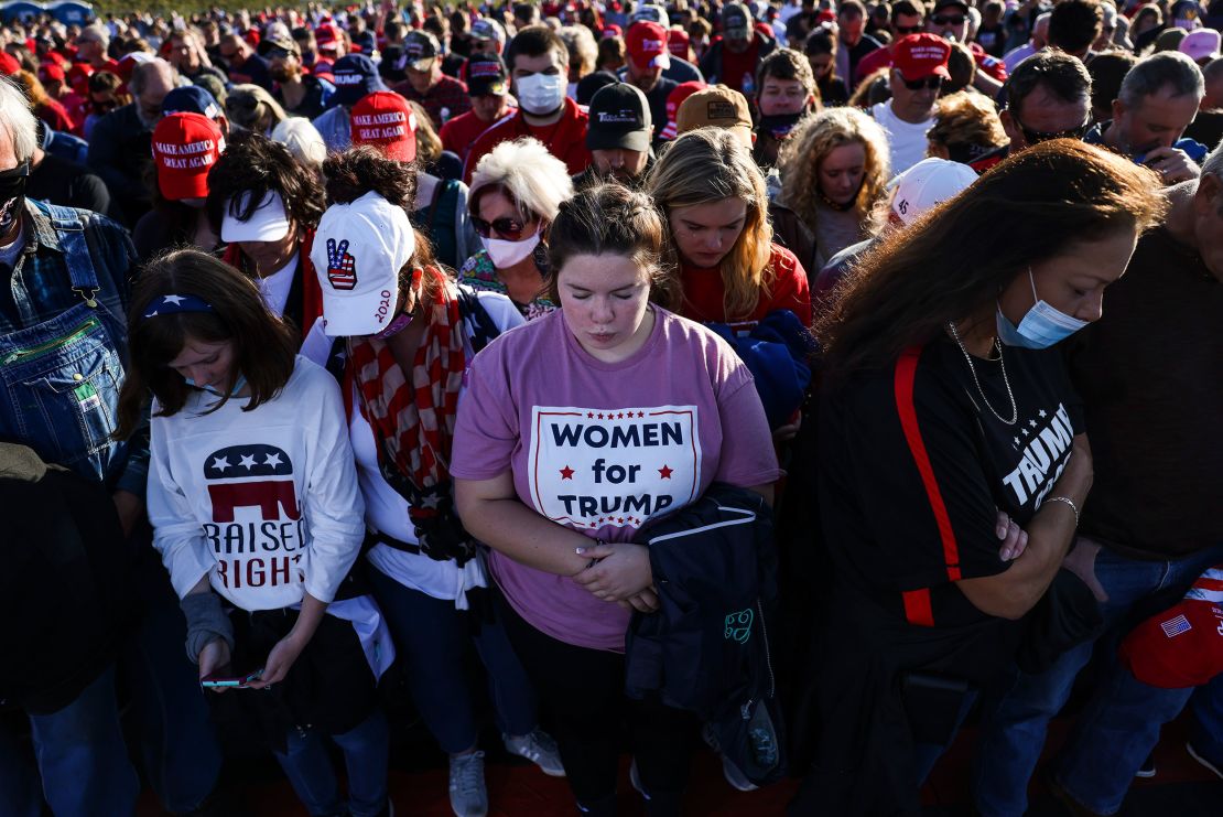 Kyndel Crouch, center, bows her head in prayer as she waits to hear President Donald Trump speak at a rally on November 1, 2020. in Hickory, North Carolina. 