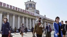 FILE PHOTO: People wearing protective face masks walk amid concerns over the new coronavirus disease (COVID-19) in front of Pyongyang Station in Pyongyang, North Korea April 27, 2020, in this photo released by Kyodo. Mandatory credit Kyodo/via REUTERS